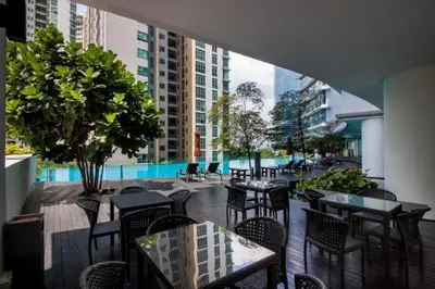 a restaurant with tables and chairs and a pool at Royale KLCC in Kuala Lumpur