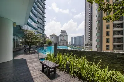 a wooden deck with a bench in a city with buildings at Royale KLCC in Kuala Lumpur