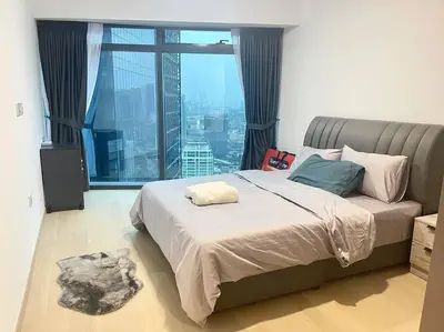 a bedroom with a bed and a large window at Eaton Residences in Kuala Lumpur