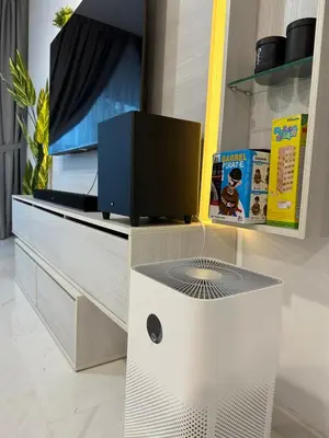a living room with a tv on a entertainment center at Eaton Residences in Kuala Lumpur
