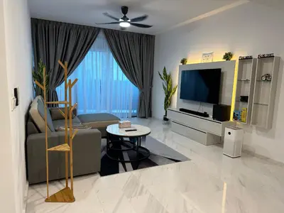 a living room with a couch and a tv at Eaton Residences in Kuala Lumpur
