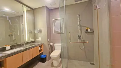 a bathroom with a toilet and a glass shower at Luxurious stay in 188 Fraser Residence Suite in Kuala Lumpur