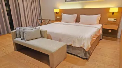 a bedroom with a large bed and a chair at Luxurious stay in 188 Fraser Residence Suite in Kuala Lumpur
