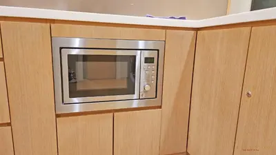 a microwave in a cabinet in a kitchen at Luxurious stay in 188 Fraser Residence Suite in Kuala Lumpur