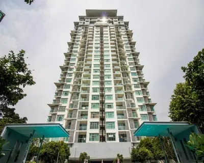 a tall building with the sun shining on it at Suasana Suites KLCC by Grand Royal in Kuala Lumpur