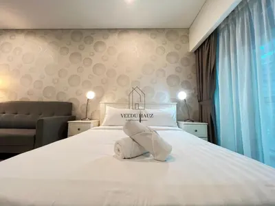 a bedroom with a bed with a stuffed animal on it at Mercu Summer Suites in Kuala Lumpur