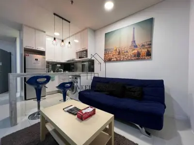 a living room with a blue couch and a table at Mercu Summer Suites in Kuala Lumpur