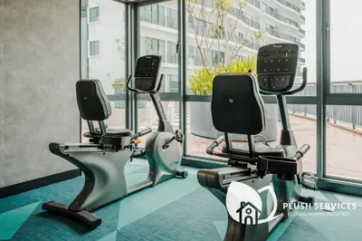 a gym with three tread machines in front of a window at Datum Jelatek by Plush in Kuala Lumpur