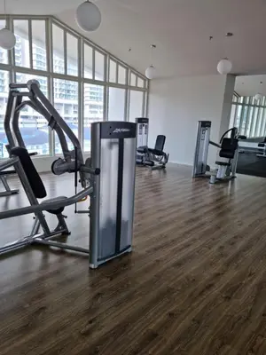 a gym with cardio equipment in a room with wood floors at Una Residence by Maya in Kuala Lumpur