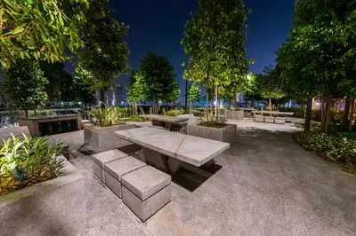 a picnic table and benches in a park at night at M Vertica Premier Suites Kuala Lumpur in Kuala Lumpur