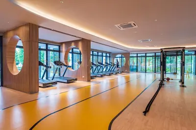 a gym with a row of treadmills and ellipticals at M Vertica Premier Suites Kuala Lumpur in Kuala Lumpur