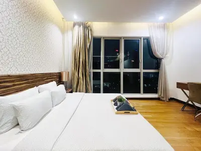 a bedroom with a large white bed and a window at Awesomestay Apartment walk to PWTC near to KLCC in Kuala Lumpur