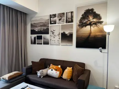 a living room with a couch with a tree on the wall at The Ooak Suite in Kuala Lumpur