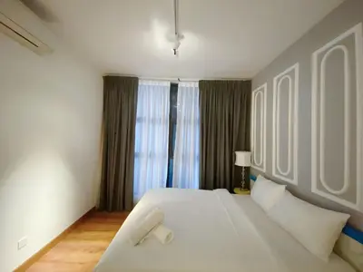 a bedroom with a white bed and a window at Arte Mont Kiara By Awesomestay in Kuala Lumpur