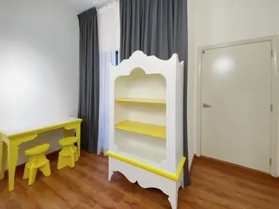 a room with a white cabinet and a yellow desk at Arte Mont Kiara By Awesomestay in Kuala Lumpur