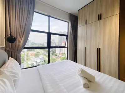 a bedroom with a white bed with a large window at Arte Mont Kiara By Awesomestay in Kuala Lumpur