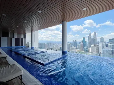 a swimming pool on top of a building with a city skyline at The Colony By Infinitum By Awesomestay in Kuala Lumpur