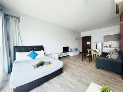a bedroom with a bed and a living room at Regalia Residence And Suites By The Relaxstay in Kuala Lumpur