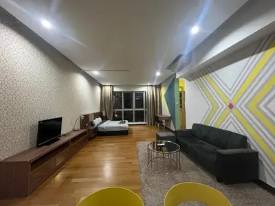 a living room with a couch and a tv at Regalia Residence And Suites By The Relaxstay in Kuala Lumpur