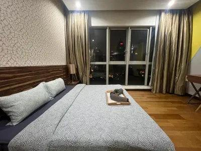a bedroom with a large bed and a large window at Regalia Residence And Suites By The Relaxstay in Kuala Lumpur