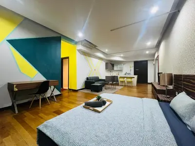 a bedroom with a bed and a living room at Regalia Residence And Suites By The Relaxstay in Kuala Lumpur