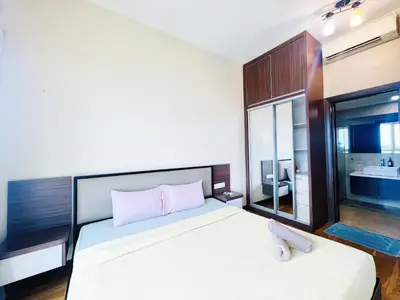 a bedroom with a large bed and a bathroom at Regalia Residence And Suites By The Relaxstay in Kuala Lumpur