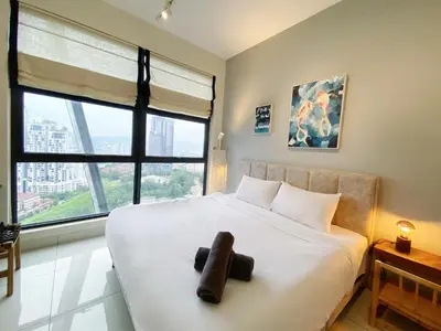 a bedroom with a large white bed with a large window at Arte Mont Kiara By The Relaxstay in Kuala Lumpur