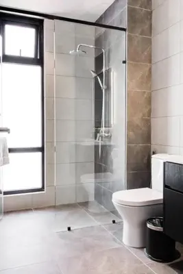a bathroom with a toilet and a glass shower at AXON Residence Kuala Lumpur in Kuala Lumpur