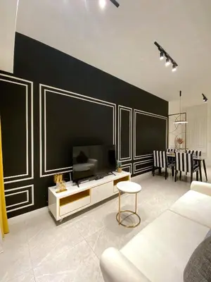 a living room with a tv and a black wall at AXON Residence Kuala Lumpur in Kuala Lumpur