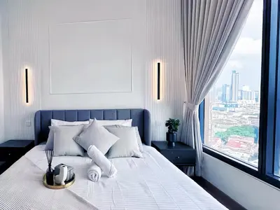 a bedroom with a white bed with a large window at Lucentia Residence Bukit Bintang in Kuala Lumpur