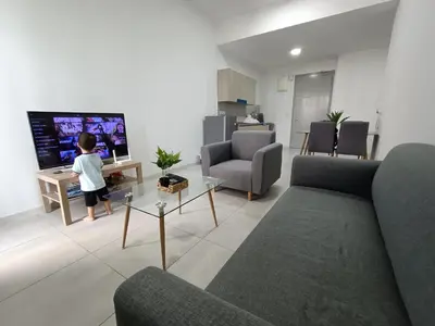 a little boy standing in a living room with a tv at The Pano Jalan Ipoh Sentul by Kenangan Homes in Kuala Lumpur