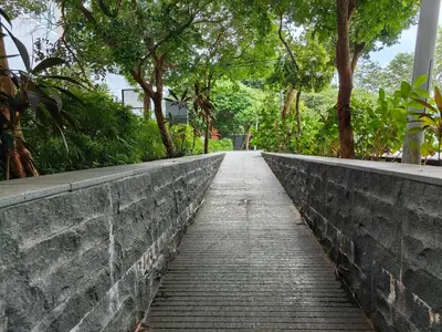 a brick path with trees on the side of a wall at 703 KLCC 5 minutes to Alor Street Ceylon Pavilion 3 Room Apt for 10 Pax in Kuala Lumpur