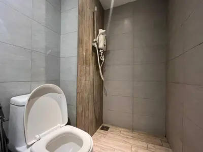 a bathroom with a toilet with a phone on the wall at Arte Plus Ampang By The Relaxstay in Kuala Lumpur