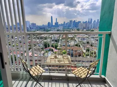 a table and chairs on a balcony with a view of a city at Ampang 2-4 pax Studio AmpPoint in Ampang
