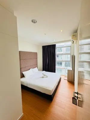 a bedroom with a white bed with a large window at Bintang Goldhill Guest House in Kuala Lumpur