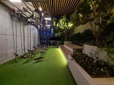 a room with a green floor with benches and plants at Romantic Log Cabin 2 - Heart of KL, near KLCC/KL Tower in Kuala Lumpur