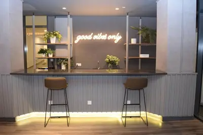 a bar with two stools in front of a counter at Romantic Log Cabin 2 - Heart of KL, near KLCC/KL Tower in Kuala Lumpur