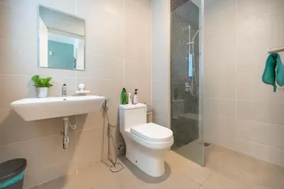 a bathroom with a toilet and a sink and a shower at Cozy Studio near TRX By Rumabnb in Kuala Lumpur