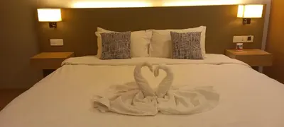 a bed with two swans made out of towels at Cozy Apartment with Jacuzzi and Sauna at 188 Suites Klcc in Kuala Lumpur
