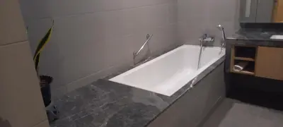 a white bath tub in a bathroom with a counter at Cozy Apartment with Jacuzzi and Sauna at 188 Suites Klcc in Kuala Lumpur