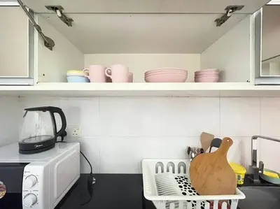 a kitchen with a microwave and a counter with dishes at Binjai 8 Premium Soho, KLCC, nearby LRT by EC in Kuala Lumpur