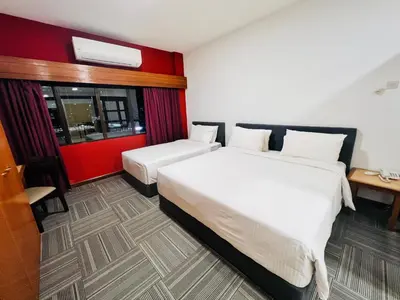 a hotel room with two beds and a red wall at Menara PGRM By Minsu in Kuala Lumpur