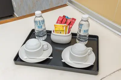 a tray with two cups and plates and water bottles at Menara PGRM By Minsu in Kuala Lumpur