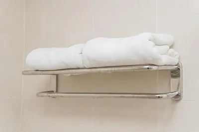 a stack of towels on a shelf in a bathroom at Menara PGRM By Minsu in Kuala Lumpur